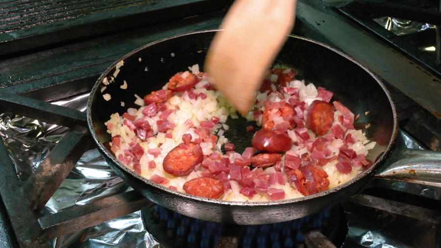 Sofreír la cebolla con un toque de sal y añadir el chorizo y el jamón y dejar que se integre todo bien