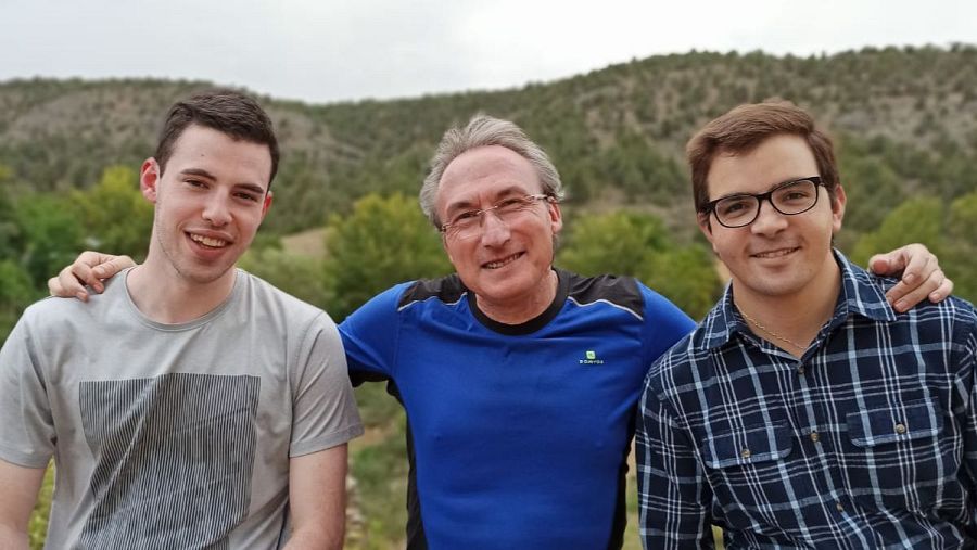 Tres hombres sentados, vestidos con ropa deportiva y sonriendo a la cámara