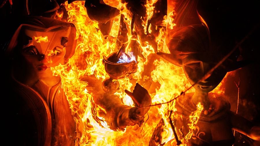 Detalle de unos ninots engullidos por el fuego durante la cremà infantil