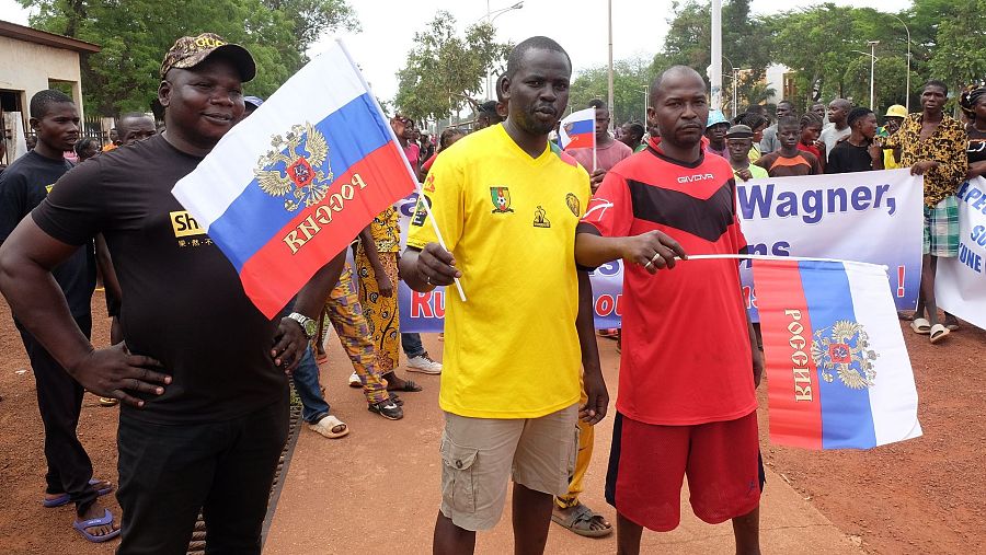 Dos hombres de raza negra con banderas de Rusia.