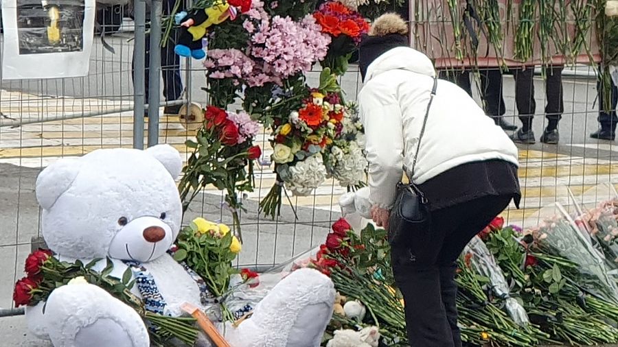 Una persona deposita flores y peluches en un memorial improvisado en Moscú.