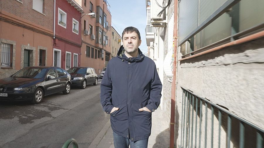 Un hombre camina por una calle de un barrio obrero madrileño