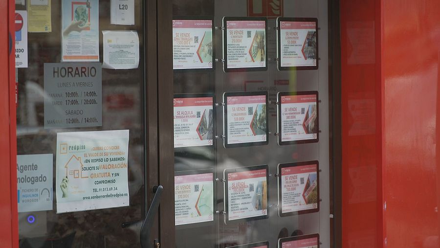 Anuncios de alquiler y venta de viviendas en un escaparate de una agencia inmobiliaria.