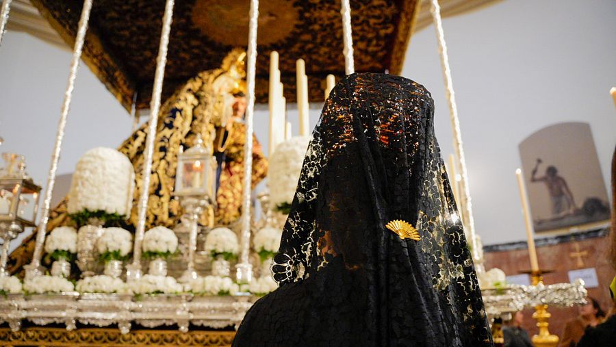 Una mujer vestida de mantilla reza a La Virgen del Mayor Dolor y Traspaso