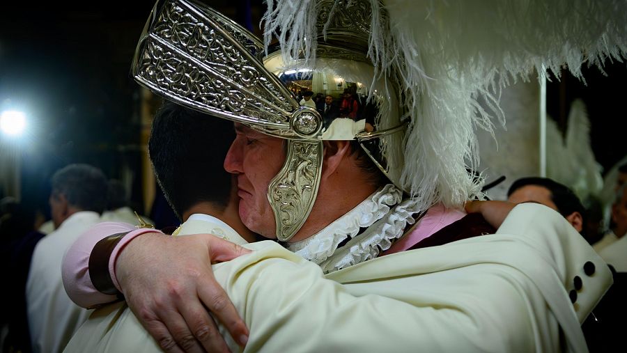 Un Armao de la Hermandad de La Macarena abraza a un nazareno después de saber que no podrá salir la imagen