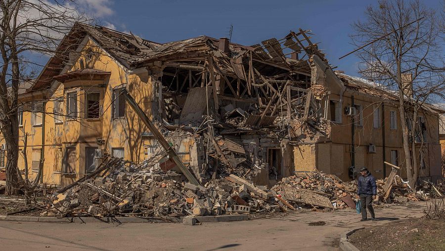 Un peatón pasea junto a un edificio dañado tras un bombardeo en la ciudad de Mikoláivka, al norte de la región de Donetsk.
