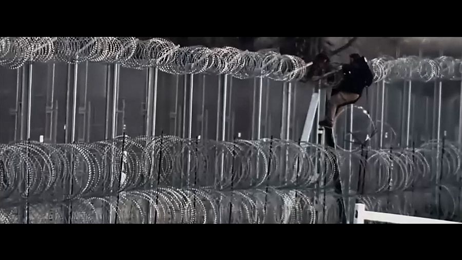 hombre saltando una valla fronteriza de alambre