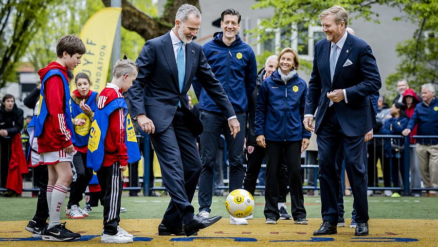 Felipe VI da patadas a un balón de fútbol durante su visita a la Fundación Cruyff en Amsterdam