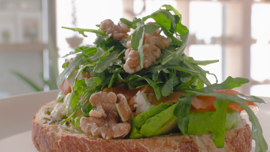 Tostada de aguacate, queso, salmón y rúcula en pan de masa madre