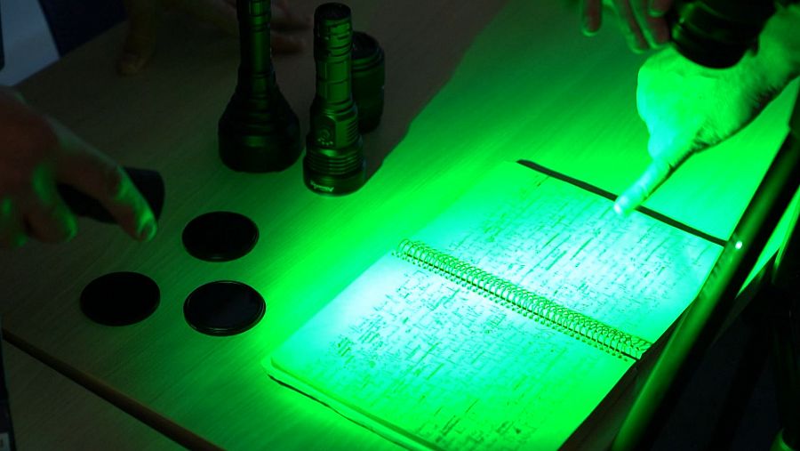 Un cuaderno manuscrito iluminado por una luz verde