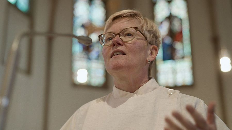 Mujer en iglesia delante de un micrófono