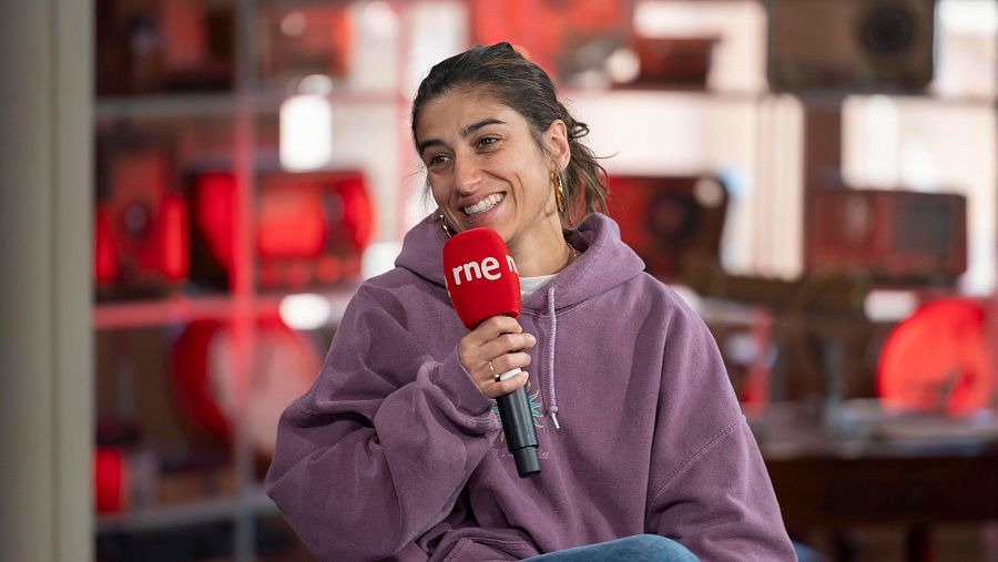 Carolina Yuste amb micro a la mà asseguda durant la seva participació a la roda de prensa