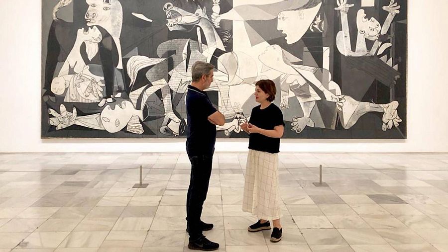 Arturo Martín y Rosario Peiró, Jefa del área de Colecciones del Museo Reina Sofía, charlan delante del Guernica durante la grabación de un programa en 2019