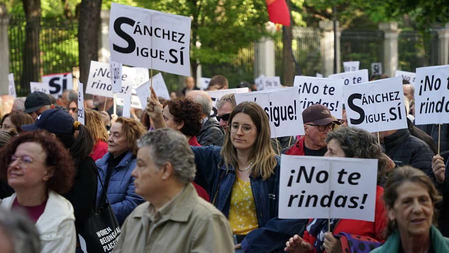 Varias personas muestran carteles de apoyo a Sánchez en la manifestación hasta el Congreso