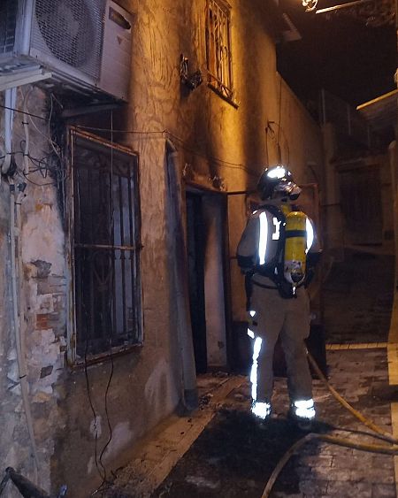 Un bombero en la entrada de la vivienda incendiada en Ricote