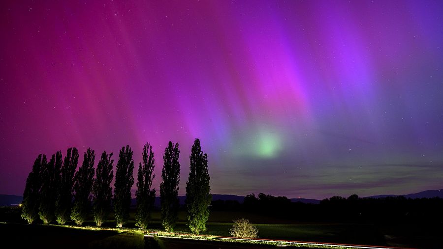 La aurora boreal en el cielo nocturno sobre el pueblo de Daillens, Suiza.