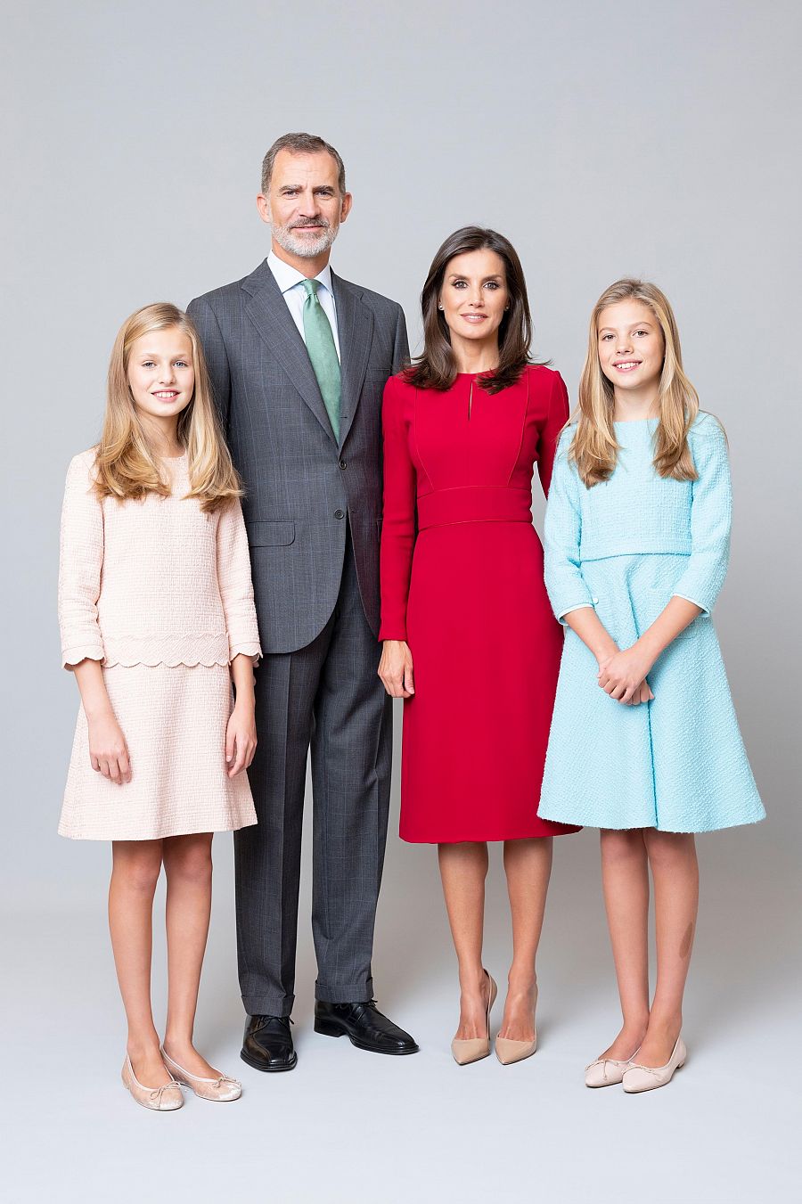 La Familia Real en su nueva fotografía familiar. Felipe VI luce traje gris y corbata verde clara, mientras que la reina Letizia porta un vestido rojo. Por su parte, sus hijas llevan la misma vestimenta que en sus fotografías individuales.