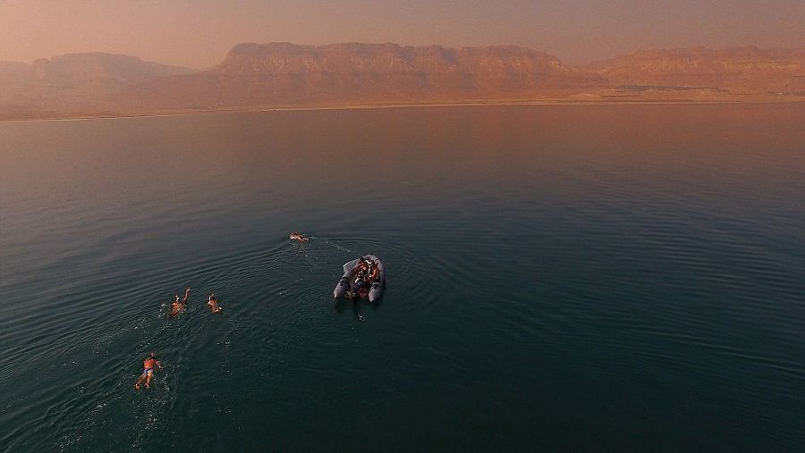 un barco y cuatro nadadores en el Mar Muerto