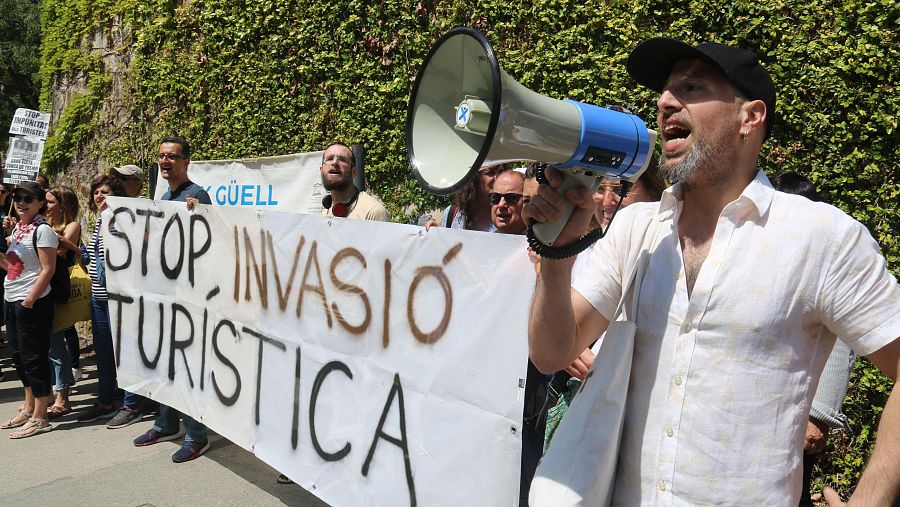 Un manifestante megáfono en mano a las puertas del Parque Güell