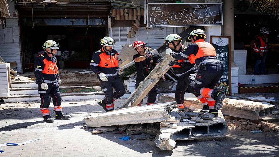Los bomberos levantando los escombros después del derrumbe de un edificio de Palma