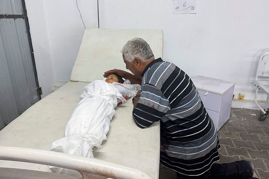 Un hombre llora junto al cuerpo de un niño víctima del ataque israelí a un campo de desplazados en Ráfah