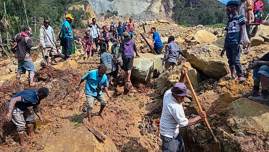 Los aldeanos buscan entre un deslizamiento de tierra en la aldea de Pogera