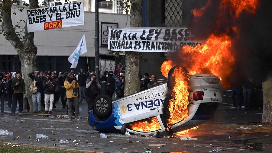 Un coche de la Cadena 3 volcado e incendiado durante las manifestaciones en Buenos Aires, Argentina