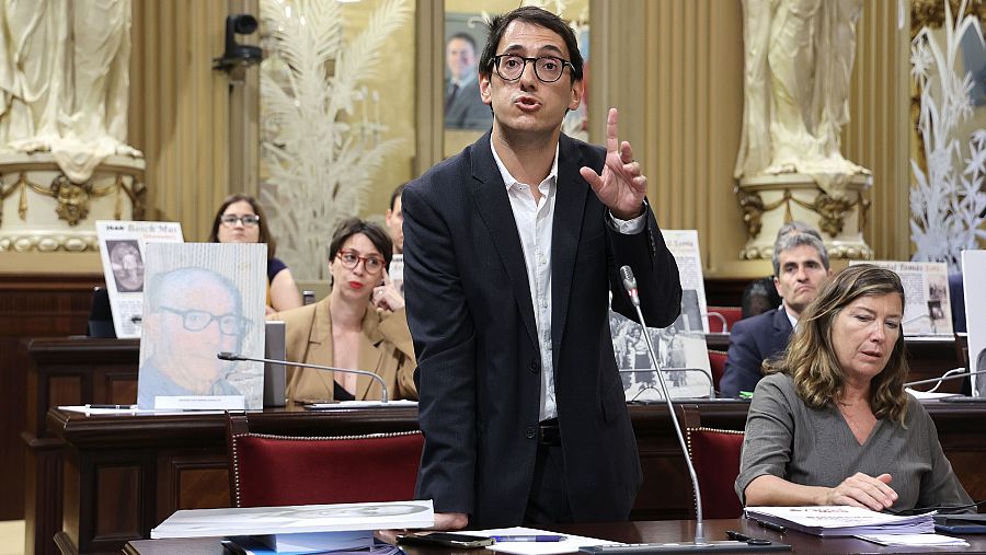 Varios diputados sostienen fotografías de víctimas mientras el diputado del PSOE Iago Negueruela interviene