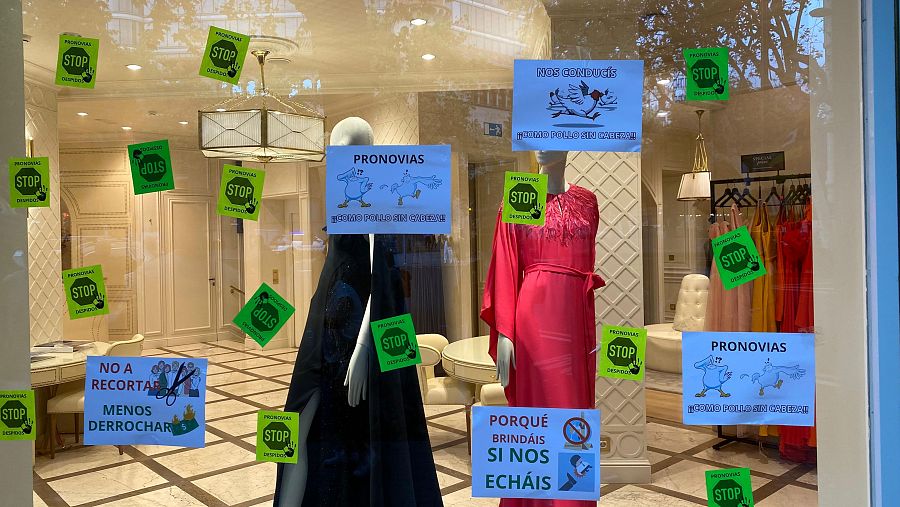 Cartells i adhesius enganxats en els vidres de la botiga de Pronovias a rambla de Catalunya
