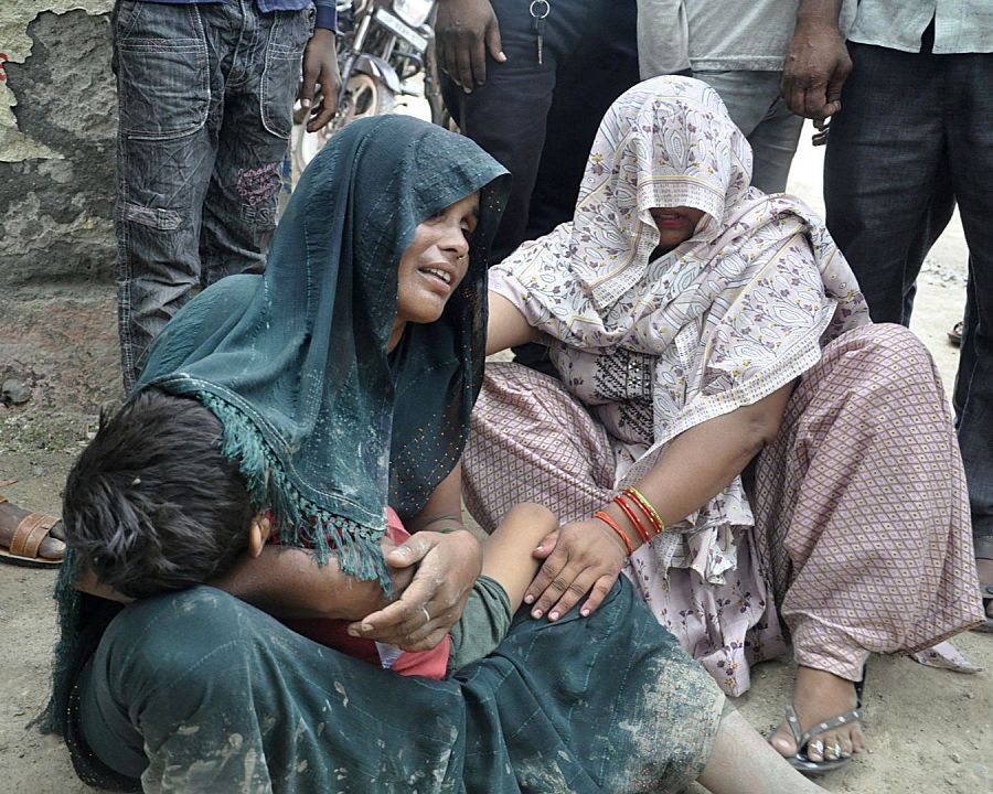 Una mujer es consolada mientras llora la muerte de su hijo en la estampida a las puertas del hospital