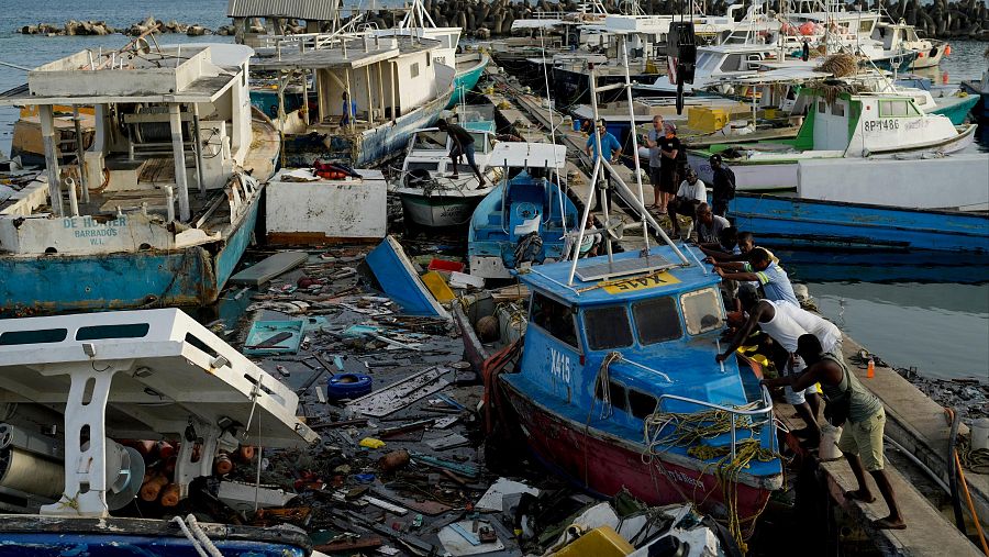 Pescadores empujan un barco dañado por el huracán Beryl en Bridgetown, Barbados