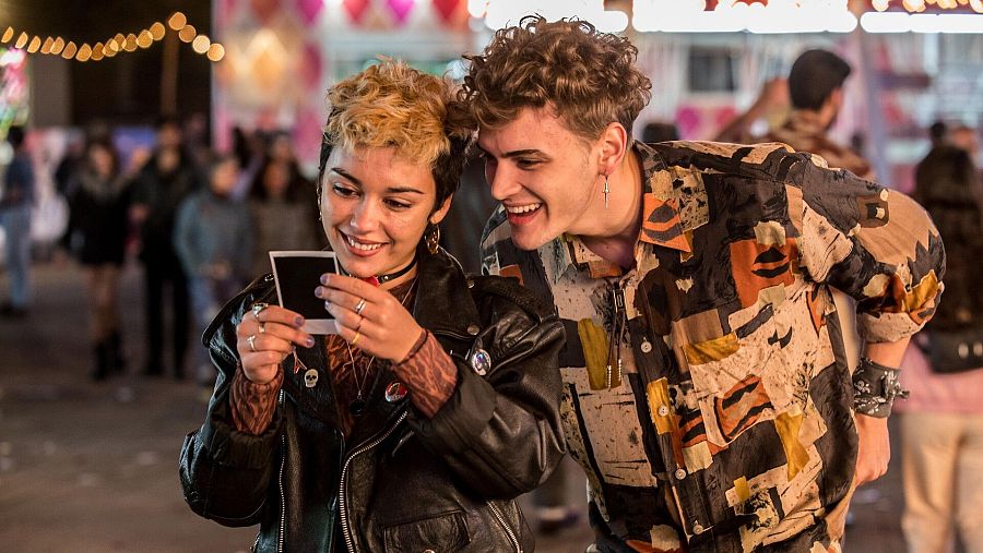 Los actores Carla Díaz y Gabriel Guevara sonriendo a una fotografía impresa