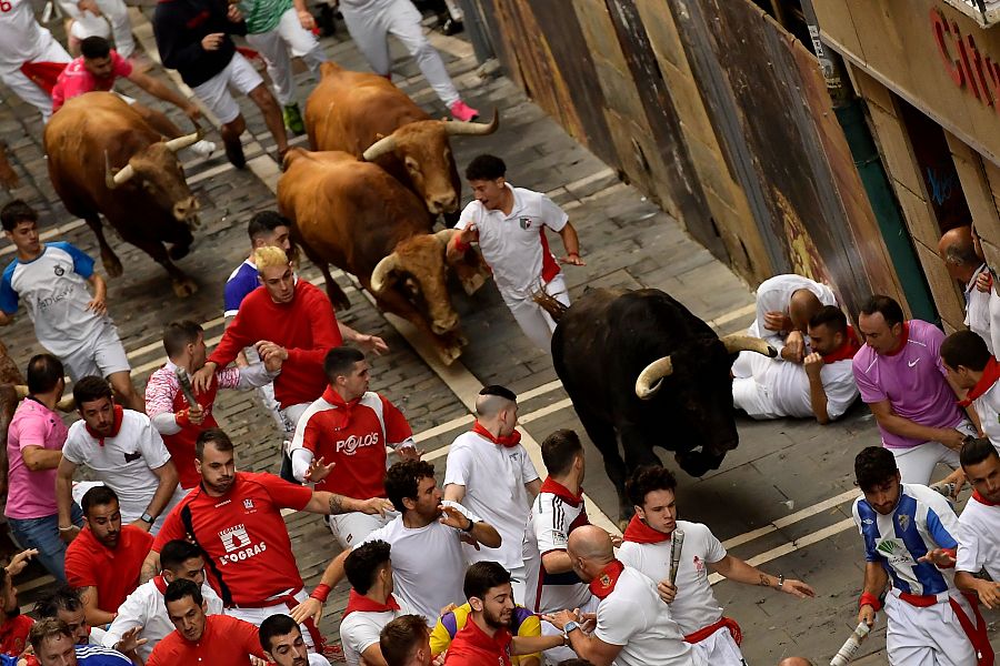 Mejores imágenes del quinto encierro de San Fermín 2024: un toro negro se adelanta en Mercaderes