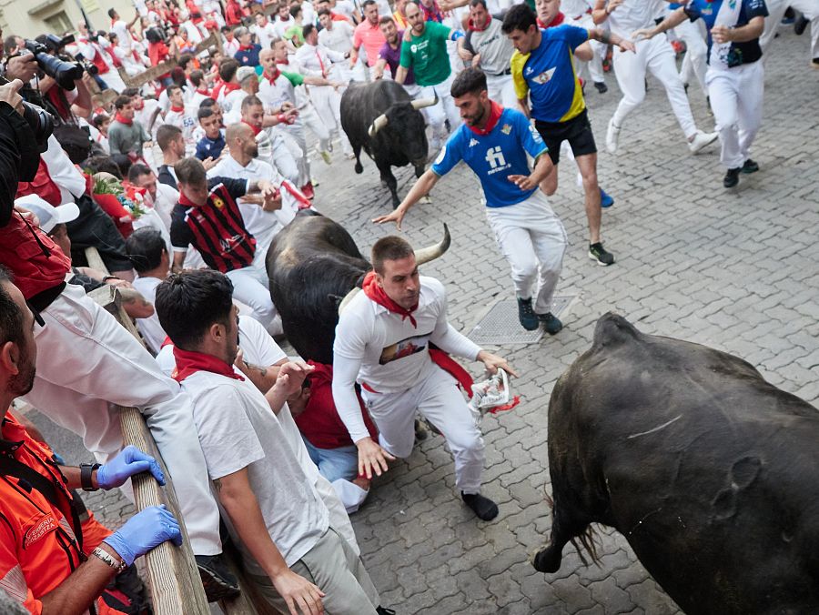 Mejores imágenes del quinto encierro de San Fermín 2024: un mozo cae en el callejón