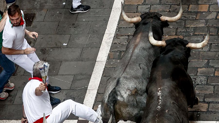 Los mozos perseguidos por los toros de la ganadería sevillana de Miura durante el último encierro de los Sanfermines 2024, este domingo, en Pamplona. EFE/Jesús Diges