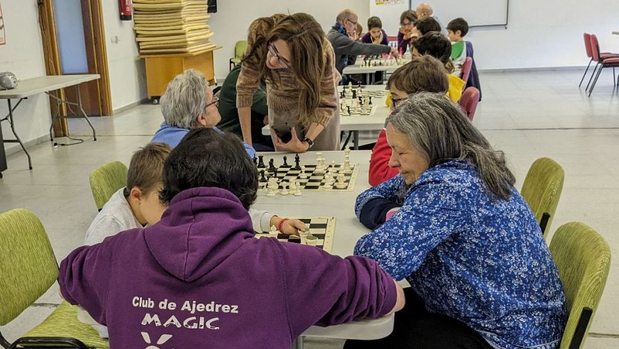 Niños y ancianos jugando al ajedrez.