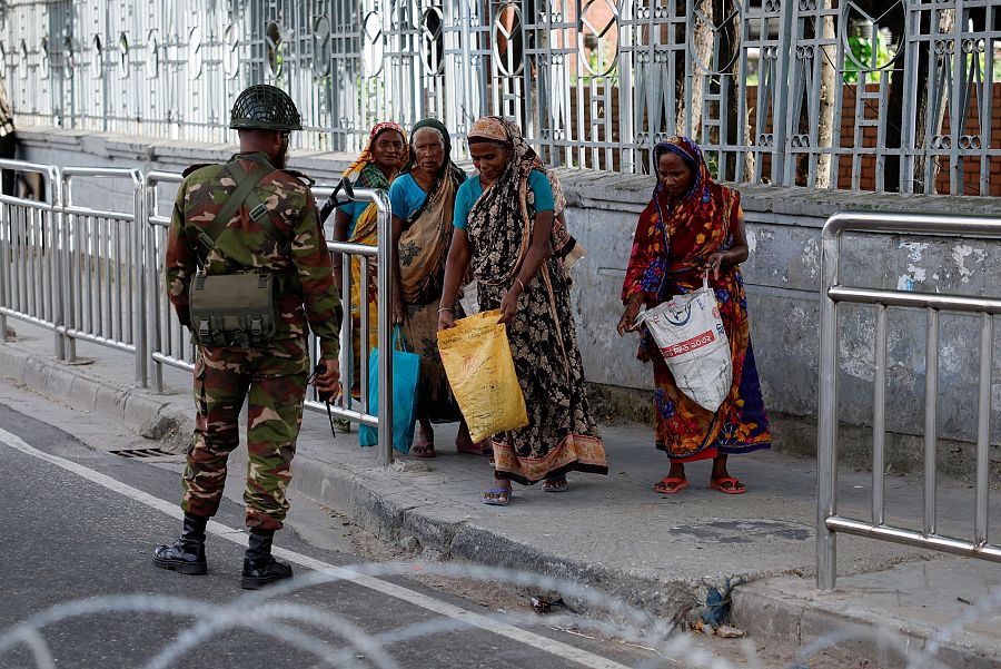 Un soldado controla las bolsas de mujeres que han salido a comprar durante la pausa del roque de queda (REUTERS/Mohammad Ponir Hossain)