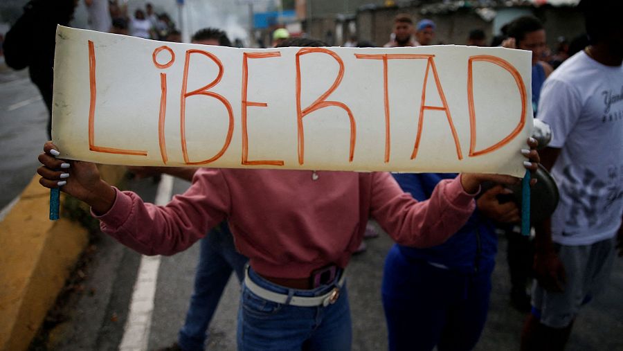 Una persona sostiene un cartel con la palabra 