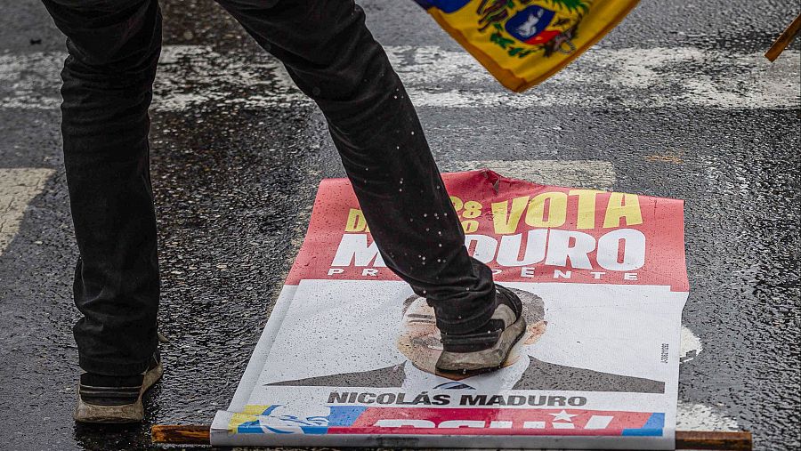 Una persona pisa un cartel electoral de Nicolás Maduro en Caracas, Venezuela