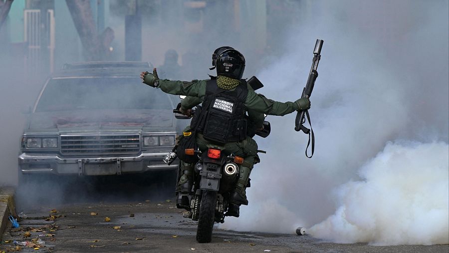 Miembros del escuadrón antidisturbios de la Guardia Nacional lanzan gases lacrimógenos en Caracas, Venezuela