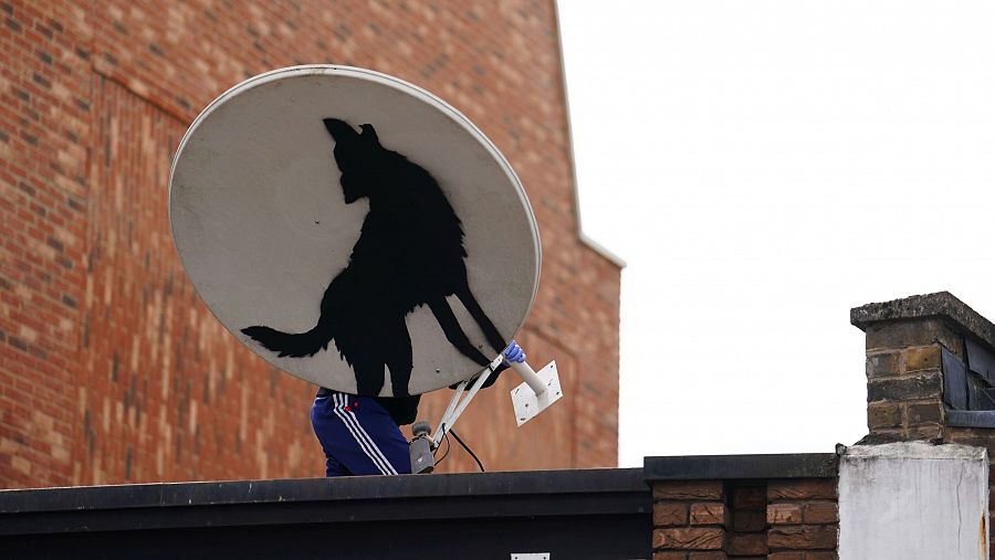 Momento en el que un encapuchado roba una de las obras de Banksy (Jordan Pettitt/PA via AP)