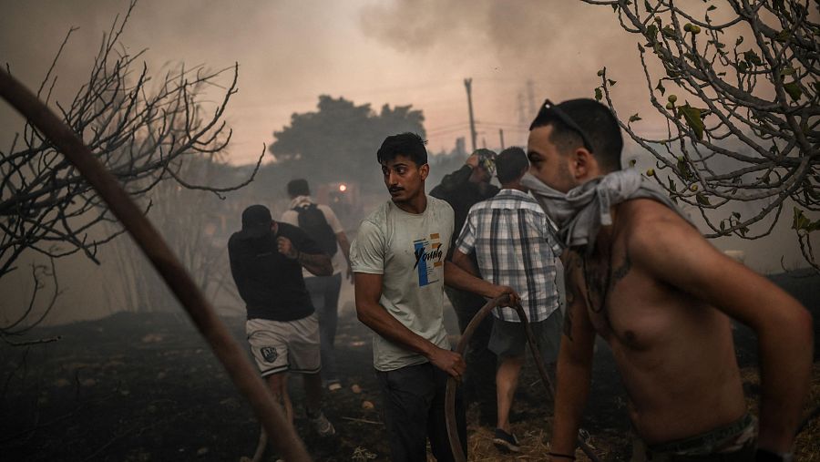 Voluntarios intentan extinguir un incendio forestal cerca de Penteli. Los incendios que rodean Atenas dejan una primera muerte.