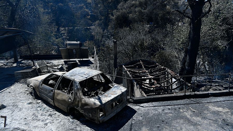 Un vehículo calcinado y varias viviendas en ruinas tras el incendio forestal que ha arrasado el barrio de Nea Penteli en Atenas. Continúan por cuarto día consecutivo los esfuerzos por frenar los incendios que cercan Atenas.