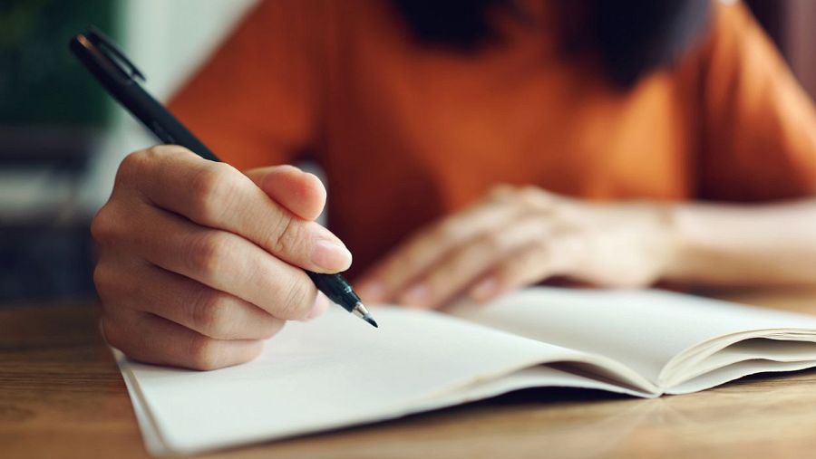 Una mujer comenzando a escribir en una libreta