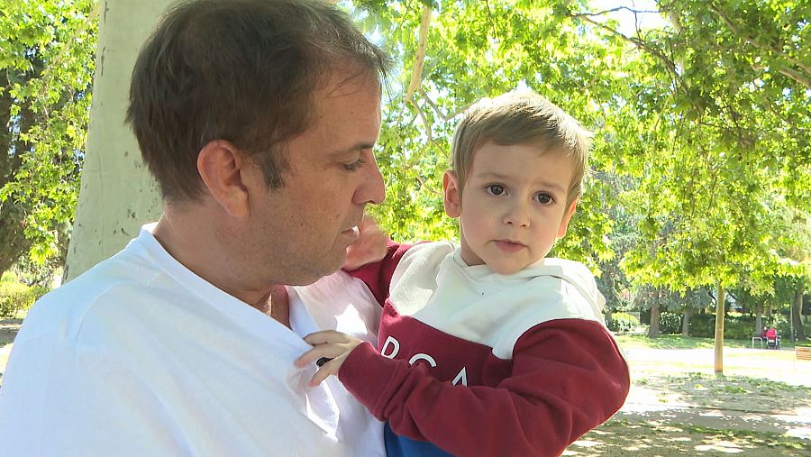 Santino en brazos de su padre Cristóbal en un parque de Barcelona