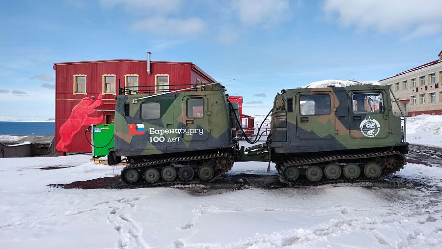 camión oruga con casa roja de fondo en paisaje polar