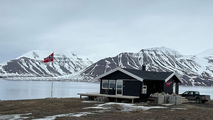 Una casa al lado de Longyearbyen con una bandera noruega ondeando