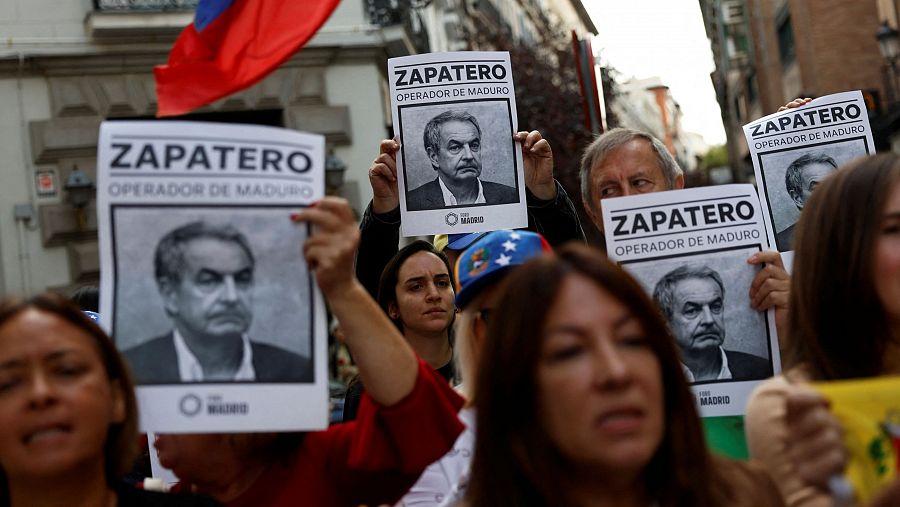 Simpatizantes de Edmundo González sostienen carteles contra el expresidente José Luis Rodríguez Zapatero