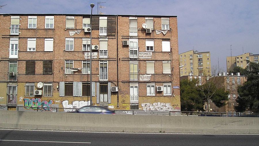 Lonas con mensjaes contra la Autovía cuelgan de las ventanas en el barrio de Batán