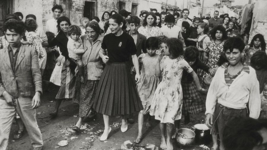 El barraquismo siguió siendo un fenómeno extendido en Barcelona durante buena parte del siglo XX. En esta foto de 1952, la bailarina Carmen Amaya pasea por el barrio de barracas del Somorrostro, en la playa de la Barceloneta